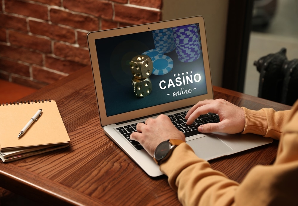 online casino - Man playing poker on laptop